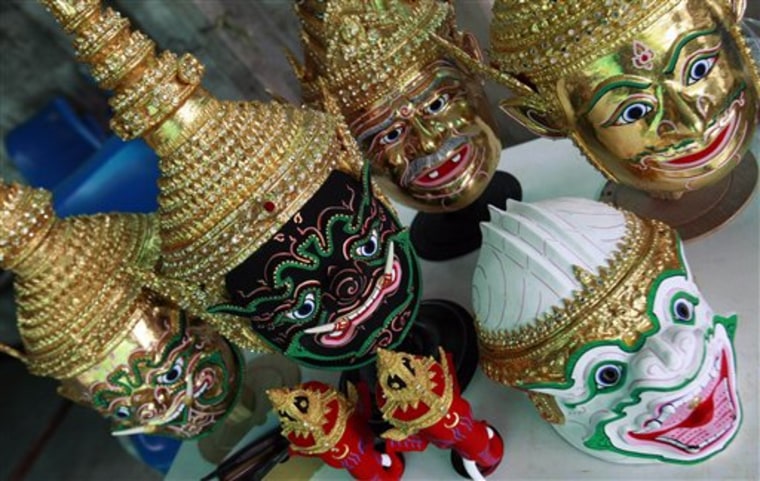 This Aug. 8, 2010 photo shows various kinds of Khon masks made by Prateep Rodpai on a table at his home in Bangkok, Thailand.  Rodpai is one of Thailand's last traditional Khon mask makers. These types of masks are the keystones of ornate glittering costumes used in the stylized classical Thai dance form known as Khon.  (AP Photo/Apichart Weerawong)
